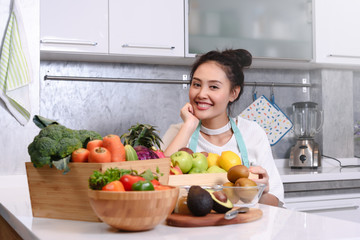 Woman in kitchen with various kind of vegetable and fruits that all are good for health and no meat, vegan lifestyle