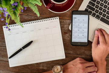 SEPTEMBER 17, 2018: Working table top with organizer for monthly planing with a pen, Macbook air,...