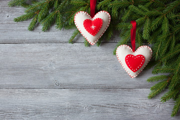 Wooden background with christmas tree branches and a red heart decoration
