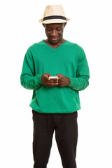 Young happy African man smiling and using mobile phone 