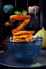 Pumpkin pancakes are falling into the blue bowl