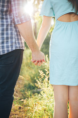 Couple in love holding hands against the setting sun