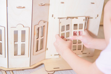 the child collects the house from the wooden designer. a concept on construction of the house.