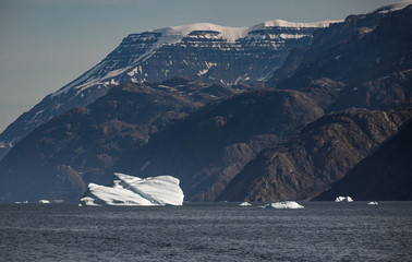 iceberg in front of Greenlandic mountain range