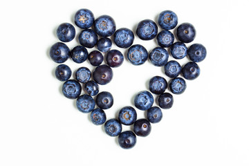 Blueberries in the shape of heart on an isolated white watercolor background with a single raspberry in the center. The concept of St. Valentine's Day.