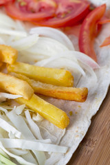 Ingredients for cooking shawarma lie on a pita bread. Middle Eastern dish to grill.