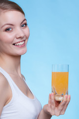 Woman holding glass of orange flavored drink