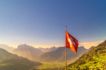 Swiss flag against scenery mountain range , Switzerland.