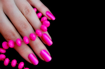 Women's fingers with pink beads and beautiful manicure