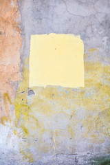 Colorful color concrete wall with cracks and painted yellow square