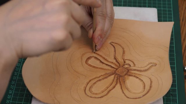 craftsman stamps the relief  of flower on  leather with Beveler Stamping tool