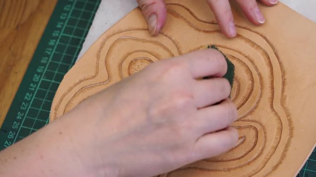 craftsman dampens and stamps the flower on leather