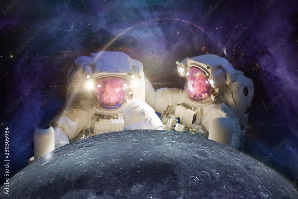 Wall mural two huge astronauts observe the moon against the background of the galaxy. elements of this image fu