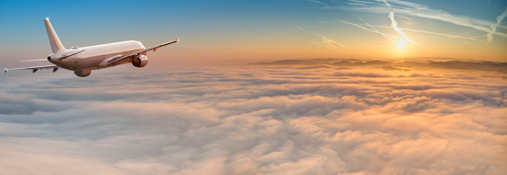 Fototapeta Commercial airplane flying above dramatic clouds.