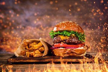 Tasty burger with french fries and fire.