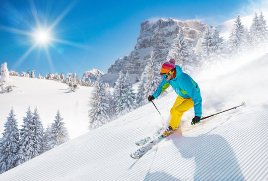 Skier skiing downhill in high mountains