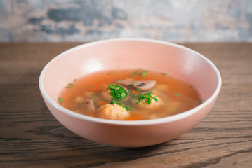 soup with meatballs and mushrooms, parsley on the wooden table
