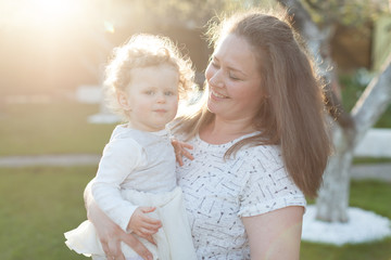 Obraz premium Mother with her little curly daughter playing on the background