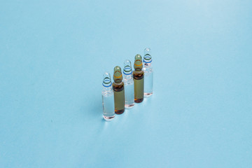 Vaccine ampoules on a blue background. Vaccine concept for children and adults against malaria,...