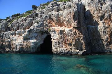 dark cave in the rock on the sea, blue sky.