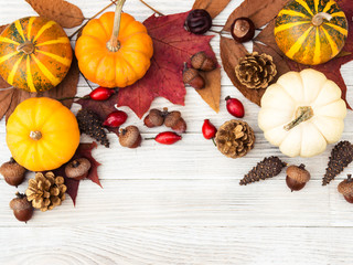 Fototapeta premium Thanksgiving Day. Vegetables and berries. White and orange pumpkins, cones and nuts, autumn leaves. Gifts of nature. Gif box. Happy Thanksgiving. Be thankful. Gather with family. Harvest.