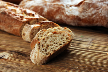 Different kinds of bread and bread rolls on board from above. Kitchen or bakery