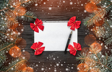 Letter for Santa Claus on black background, fir tree branches. Space for text, top view. Effect of...