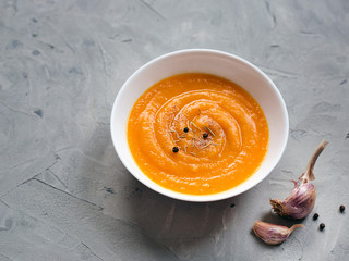 Pumpkin soup, top view, copy space. Seasonal autumn food - Spicy pumpkin soup with garlic and pepper