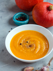 Pumpkin soup with garlic and pepper and organic pumpkins, copy space. Seasonal autumn food