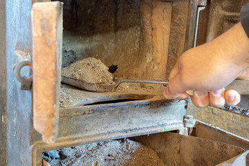 Cleaning an old stove, dispose of ash in the ash box.