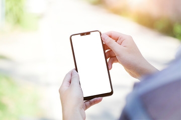 Mock up smartphone of hand holding black mobile phone with blank white screen