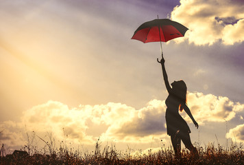 photo of the beautiful young woman with umbrella in the field