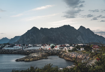 Sunrise and Sunset at Henningsvaer, fishing village located on several small islands in the Lofoten archipelago, Norway over a blue sky with clouds.