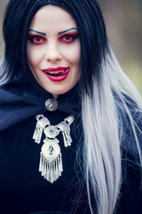 Portrait of vampire woman with long hair, red eyes