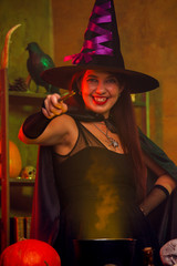 Portrait of witch in black hat with hand outstretched with magic wand