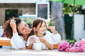 Naklejka premium Mother and daughter are sitting in a cafe