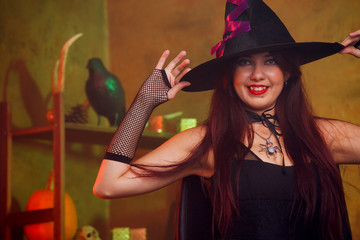Image of witch in black dress and hat in magic room