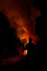 Fototapeta na wymiar Man silhouette looking at the fire at night