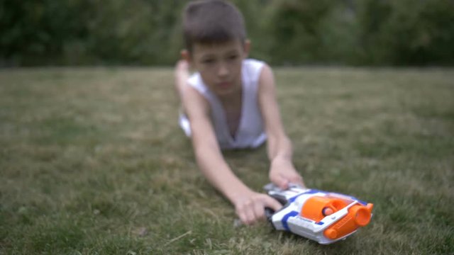 teen boy playing with toy gun, outdoors