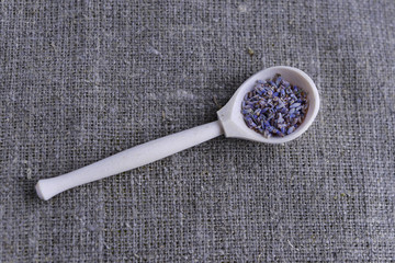 wooden spoon with dried lavender flowers on canvas