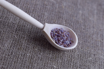 wooden spoon with dried lavender flowers on canvas