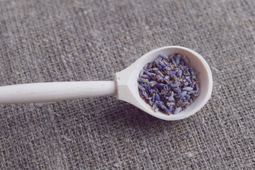 wooden spoon with dried lavender flowers on canvas