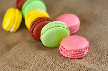 Macarons cakes of different colors on a burlap