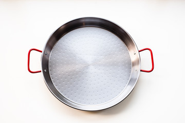 New unseasoned carbon steel paella pan isolated on white background, flat lay