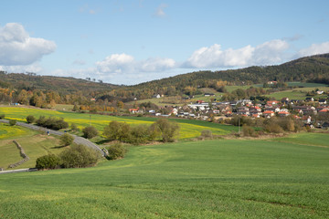 Fototapeta na wymiar A view of the hill called Helfštýn on the field and the surrounding can be seen village Krhová during a sunny day