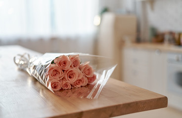 Kitchen table with a bouquet of pink roses. Kitchen background.