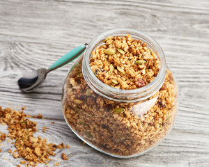Homemade granola in a glass jar on a wooden table