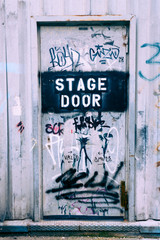 Stage door written on an old metal door covered in scribbles