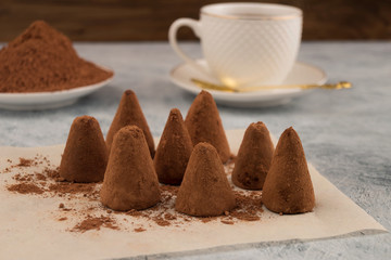 Chocolate candies in cocoa powder, utensils for tea.