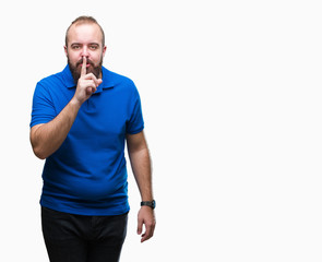 Young caucasian hipster man wearing blue shirt over isolated background asking to be quiet with finger on lips. Silence and secret concept.